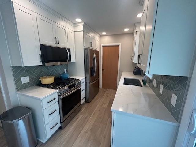 3412 Crestmoor Pl, Des Moines, IA 50310 - kitchen featuring appliances with stainless steel finishes, light wood-style floors, white cabinets, decorative backsplash, and recessed lighting