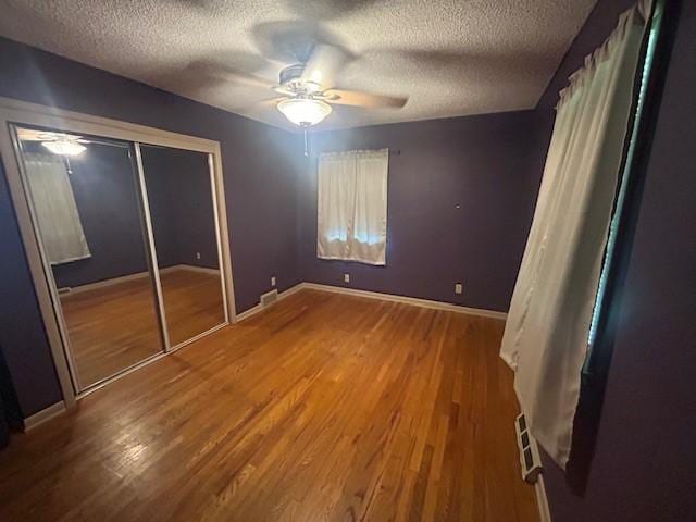 3412 Crestmoor Pl, Des Moines, IA 50310 - unfurnished bedroom with a textured ceiling, wood finished floors, a closet, and a ceiling fan