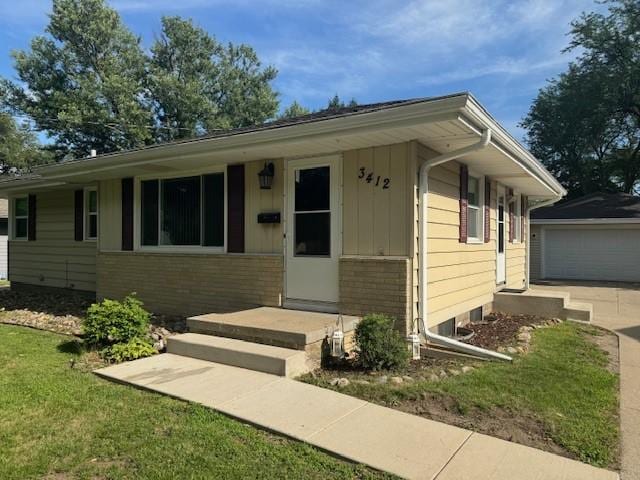 3412 Crestmoor Pl, Des Moines, IA 50310 - ranch-style house with board and batten siding, brick siding, a front yard, an outdoor structure, and a garage