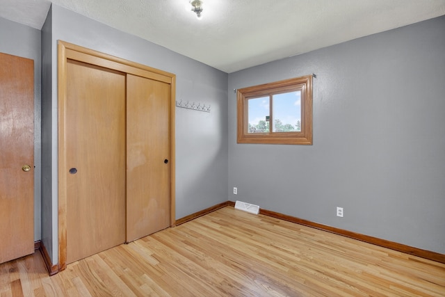 2704 Wedgewood Rd, Des Moines, IA 50317 - unfurnished bedroom with light wood-style flooring and a closet