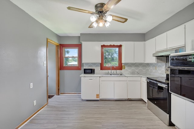 2704 Wedgewood Rd, Des Moines, IA 50317 - kitchen with black appliances, ceiling fan, under cabinet range hood, decorative backsplash, and white cabinetry