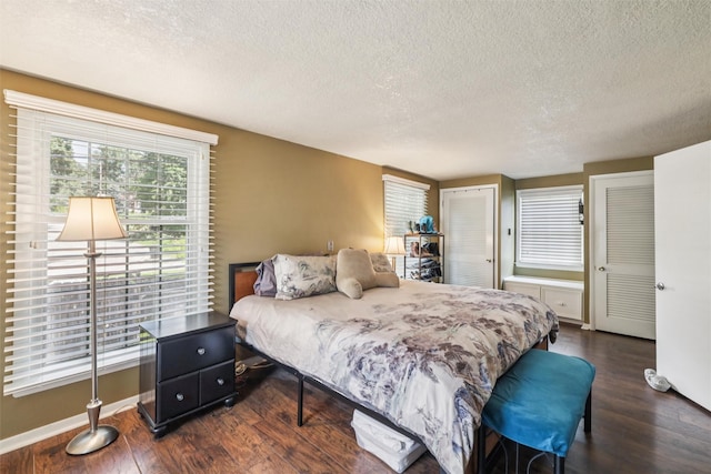 3923 Maquoketa Dr, Des Moines, IA 50311 - bedroom featuring a textured ceiling, dark wood finished floors, and multiple closets