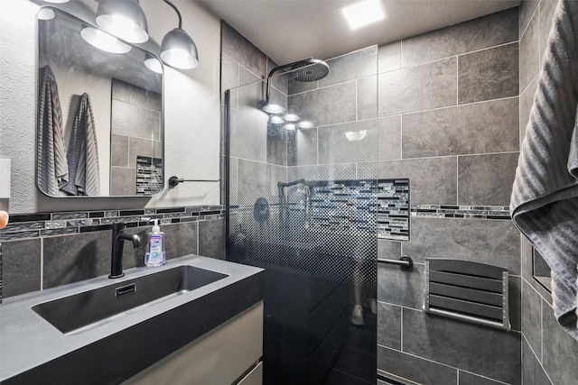 3923 Maquoketa Dr, Des Moines, IA 50311 - bathroom with vanity, a tile shower, and tile walls