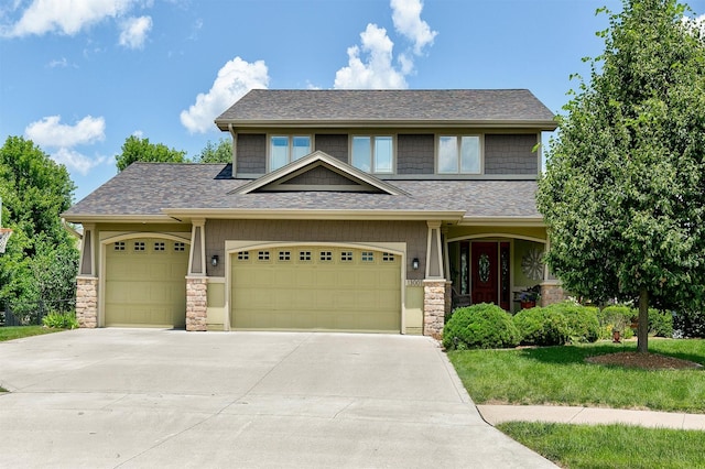 13001 Twana Dr, Urbandale, IA 50323 - view of front of property featuring stone siding, concrete driveway, an attached garage, a shingled roof, and a front lawn