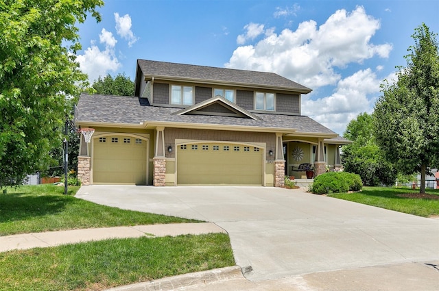 13001 Twana Dr, Urbandale, IA 50323 - craftsman-style house with stone siding, a front yard, concrete driveway, and an attached garage