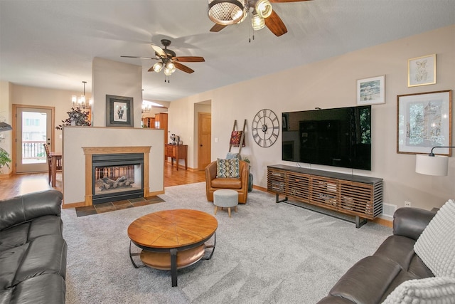 13001 Twana Dr, Urbandale, IA 50323 - living area featuring a ceiling fan, carpet, a fireplace with flush hearth, and a chandelier