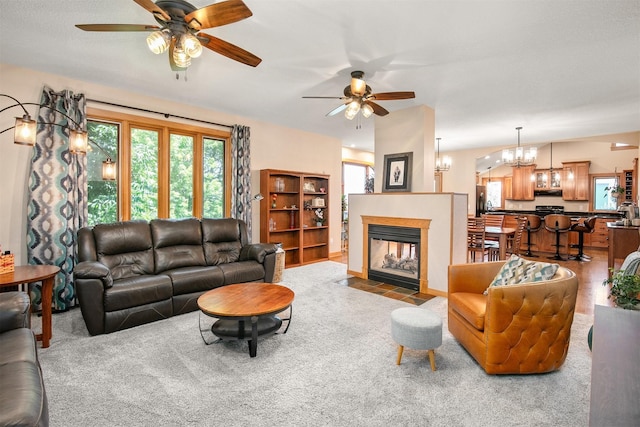13001 Twana Dr, Urbandale, IA 50323 - carpeted living area with a ceiling fan, a multi sided fireplace, and a chandelier