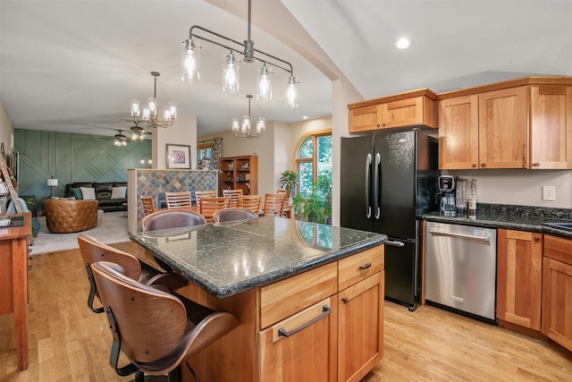 13001 Twana Dr, Urbandale, IA 50323 - kitchen featuring dishwasher, freestanding refrigerator, a chandelier, light wood-style floors, and a breakfast bar area