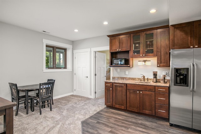 13001 Twana Dr, Urbandale, IA 50323 - kitchen featuring stainless steel refrigerator with ice dispenser, black microwave, light stone counters, recessed lighting, and glass insert cabinets