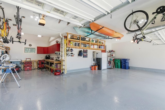 13001 Twana Dr, Urbandale, IA 50323 - garage featuring a workshop area, a garage door opener, and freestanding refrigerator
