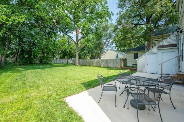 512 11th St, West Des Moines, IA 50265 - view of yard with a storage unit, outdoor dining area, and a patio