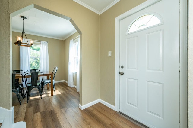 512 11th St, West Des Moines, IA 50265 - foyer entrance with ornamental molding, dark wood finished floors, a chandelier, and arched walkways