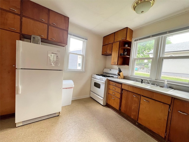 314 E 14th St N, Newton, IA 50208 - kitchen with white appliances, healthy amount of natural light, light countertops, and brown cabinets
