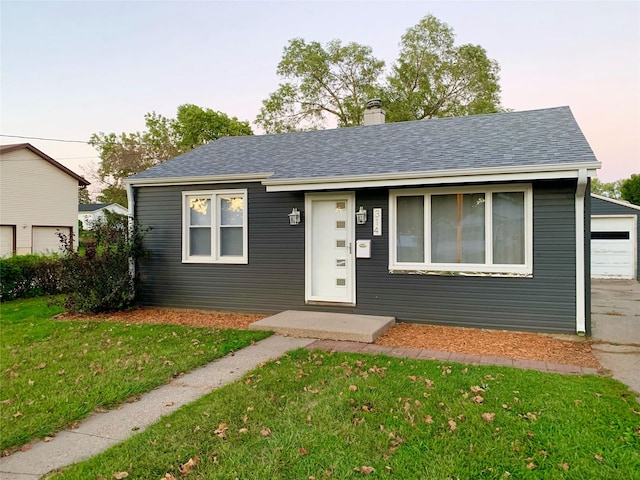 314 E 14th St N, Newton, IA 50208 - view of front of home with a front lawn, a chimney, roof with shingles, and a garage