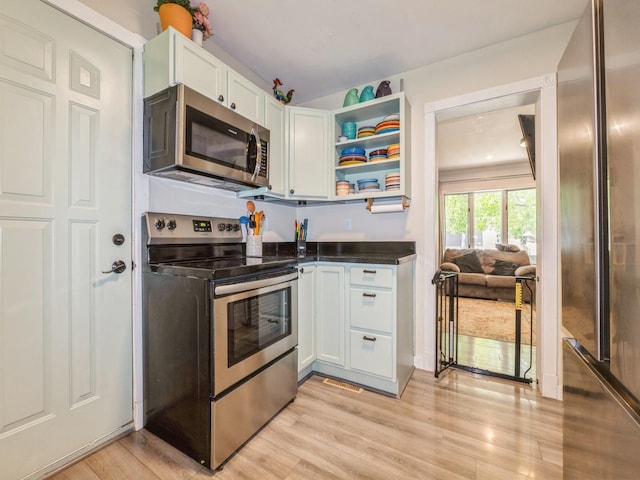 2300 Locust St, West Des Moines, IA 50265 - kitchen featuring appliances with stainless steel finishes, white cabinets, open shelves, dark countertops, and light wood finished floors