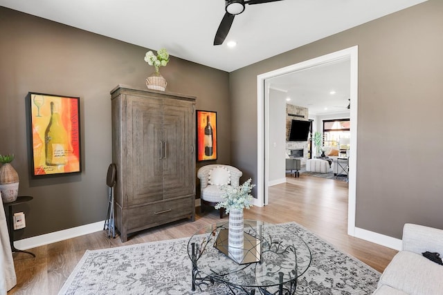 710 Peace St Unit 3D, Pella, IA 50219 - sitting room with ceiling fan, wood finished floors, a fireplace, and recessed lighting