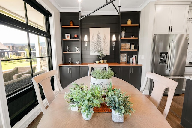 710 Peace St Unit 3D, Pella, IA 50219 - dining space featuring crown molding, wood finished floors, and built in features
