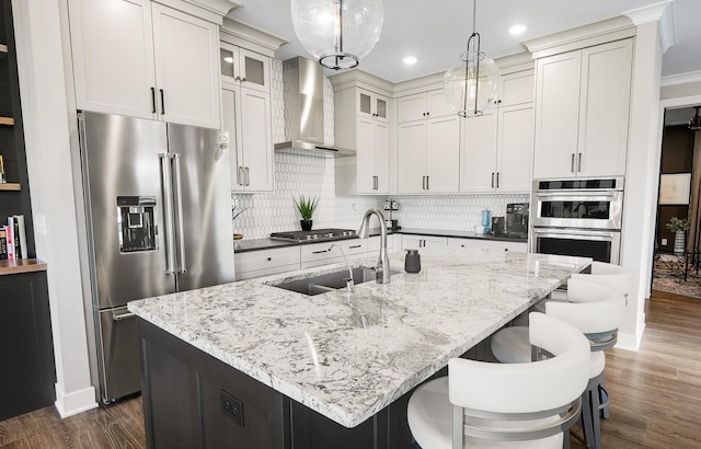 710 Peace St Unit 3D, Pella, IA 50219 - kitchen featuring stainless steel appliances, wall chimney exhaust hood, dark wood-style floors, backsplash, and recessed lighting