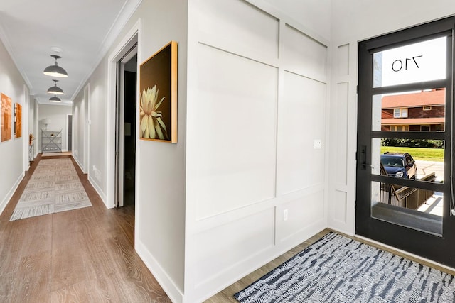 710 Peace St Unit 3D, Pella, IA 50219 - entryway featuring a decorative wall, ornamental molding, and wood finished floors