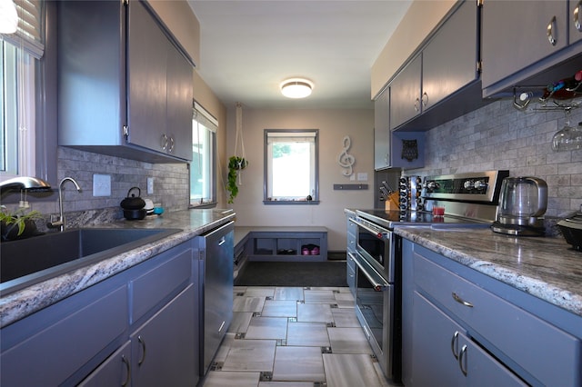 3600 Brinkwood Rd, Des Moines, IA 50310 - kitchen featuring stainless steel appliances, decorative backsplash, and blue cabinets