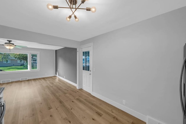 1515 Chance Ct, Adel, IA 50003 - unfurnished living room with light wood-style floors, a chandelier, and a ceiling fan