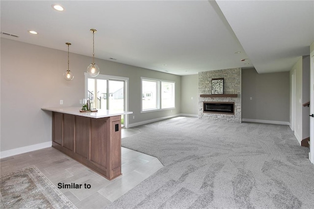 790 Hamilton Rd, Waukee, IA 50263 - kitchen with a peninsula, pendant lighting, a stone fireplace, light countertops, and recessed lighting