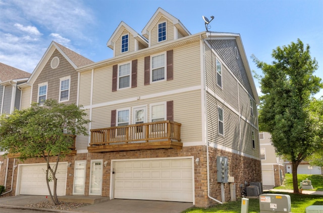 1115 Fieldstone Ln, Pleasant Hill, IA 50327 - view of front facade featuring a garage, driveway, stone siding, and a balcony