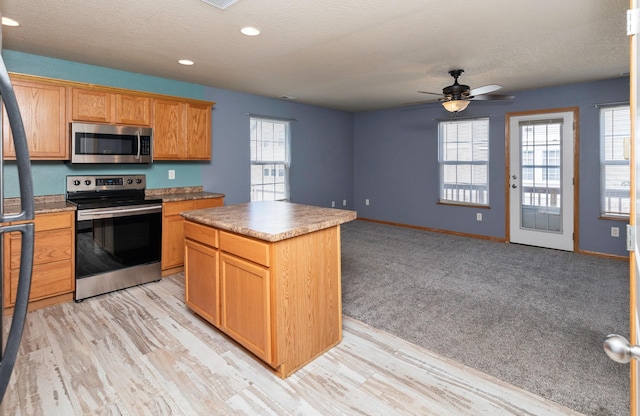 1115 Fieldstone Ln, Pleasant Hill, IA 50327 - kitchen featuring stainless steel appliances, ceiling fan, recessed lighting, a kitchen island, and open floor plan