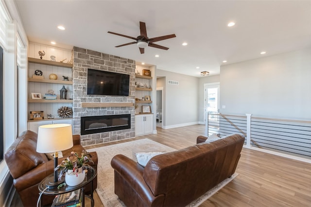 17965 Hammontree Cir, Clive, IA 50325 - living area featuring light wood finished floors, ceiling fan, a fireplace, built in features, and recessed lighting
