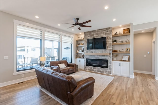17965 Hammontree Cir, Clive, IA 50325 - living area with ceiling fan, light wood finished floors, a stone fireplace, recessed lighting, and built in shelves