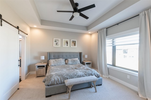 17965 Hammontree Cir, Clive, IA 50325 - bedroom with a barn door, light carpet, recessed lighting, a tray ceiling, and a ceiling fan