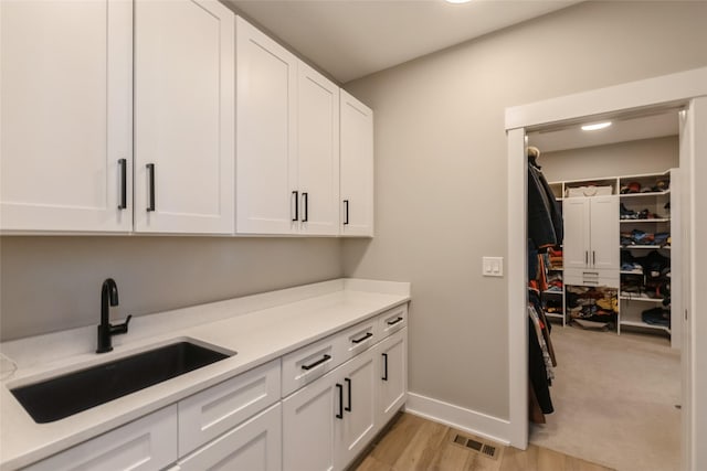 17965 Hammontree Cir, Clive, IA 50325 - laundry room with a sink and light wood-style flooring