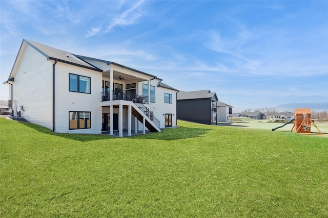 17965 Hammontree Cir, Clive, IA 50325 - back of house with stairway, ceiling fan, a yard, a wooden deck, and a playground