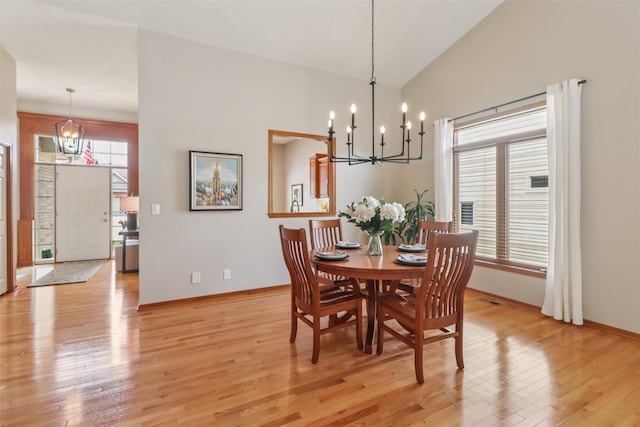 3607 152nd St, Urbandale, IA 50323 - dining area with a chandelier, light wood-type flooring, and vaulted ceiling