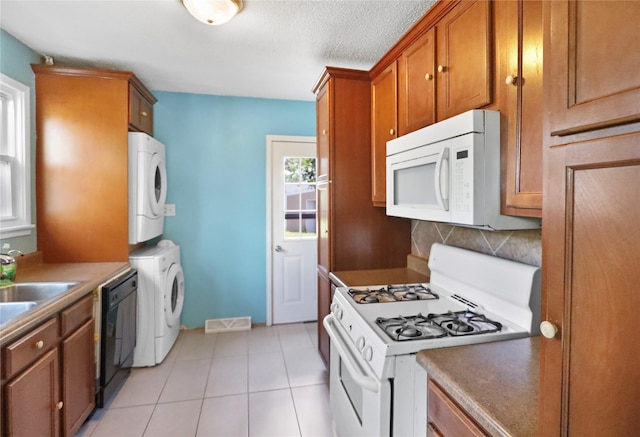 217 E Park Ave, Des Moines, IA 50315 - kitchen featuring white appliances, stacked washer / dryer, brown cabinetry, backsplash, and light tile patterned flooring