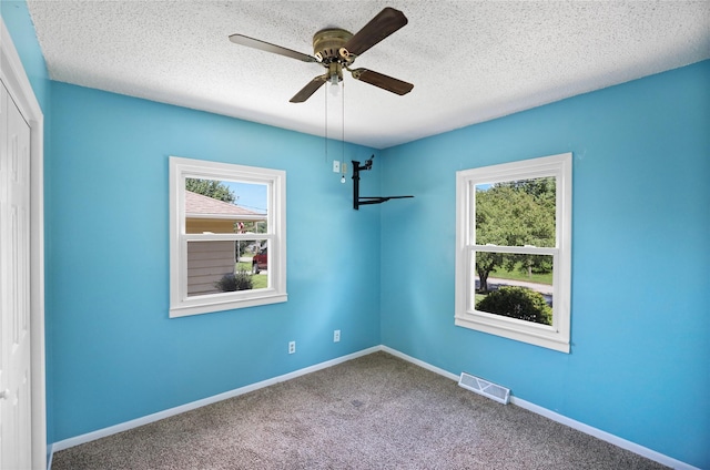 217 E Park Ave, Des Moines, IA 50315 - unfurnished room featuring healthy amount of natural light, a ceiling fan, carpet flooring, and a textured ceiling