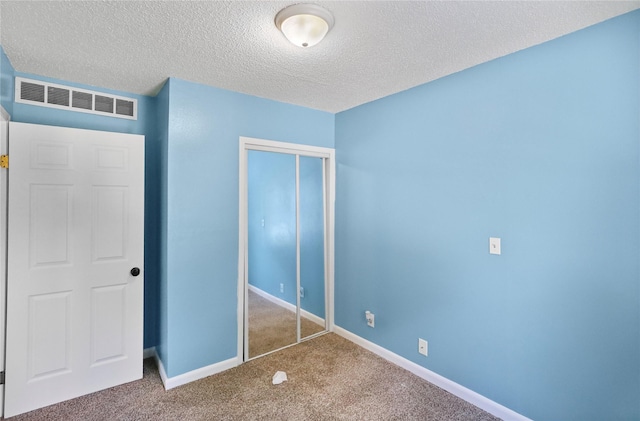 217 E Park Ave, Des Moines, IA 50315 - unfurnished bedroom featuring carpet, a closet, and a textured ceiling
