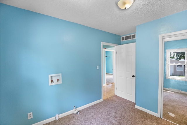 217 E Park Ave, Des Moines, IA 50315 - unfurnished bedroom featuring carpet floors and a textured ceiling