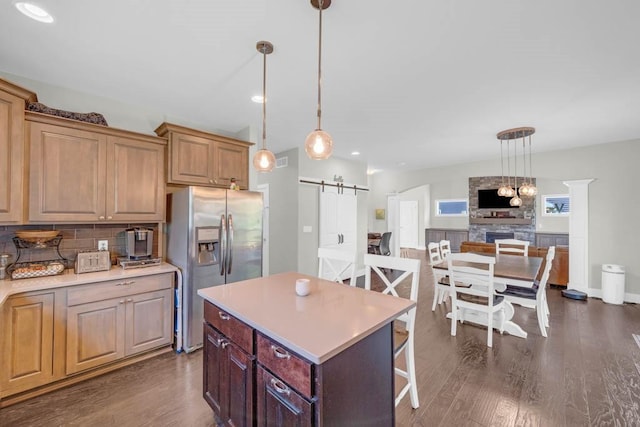 1965 SE Waddell Way, Waukee, IA 50263 - kitchen with stainless steel refrigerator with ice dispenser, a barn door, dark wood-style floors, light countertops, and recessed lighting