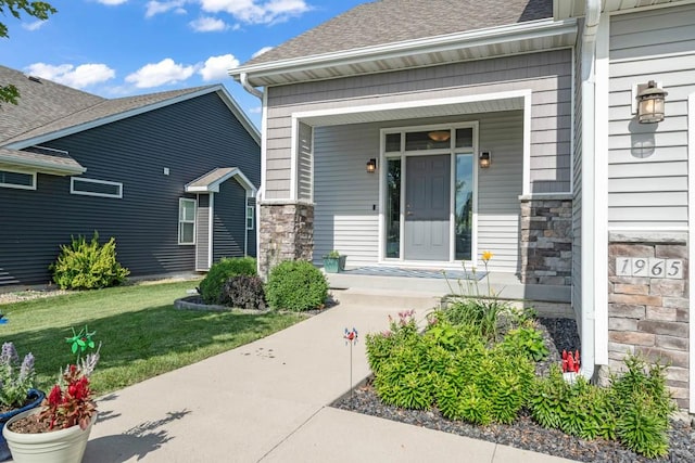 1965 SE Waddell Way, Waukee, IA 50263 - entrance to property with stone siding, covered porch, roof with shingles, and a yard