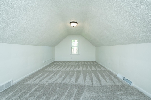 1205 Elder Ln, Des Moines, IA 50315 - bonus room featuring carpet, a textured ceiling, and vaulted ceiling
