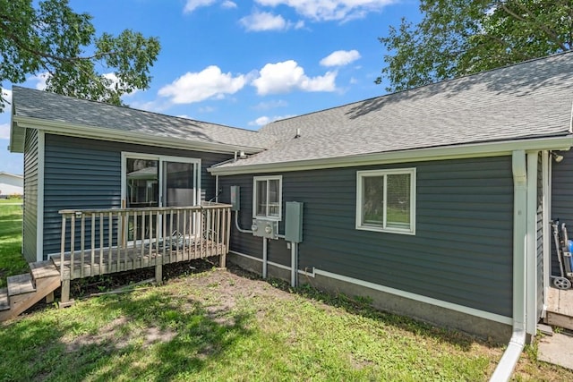 1020 SW 3rd St, Nevada, IA 50201 - rear view of house featuring a wooden deck, roof with shingles, and a lawn