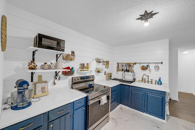 1020 SW 3rd St, Nevada, IA 50201 - kitchen with stainless steel electric range oven, blue cabinets, a textured ceiling, light countertops, and light marble finish flooring
