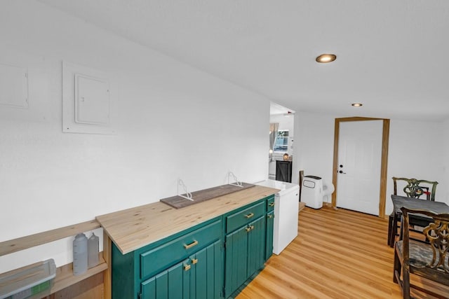 1020 SW 3rd St, Nevada, IA 50201 - kitchen featuring electric panel, light wood-type flooring, recessed lighting, green cabinets, and wood counters