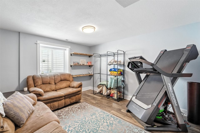 3504 Hawthorn Dr SW, Bondurant, IA 50035 - exercise room with wood finished floors and a textured ceiling