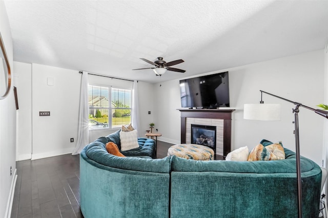 3504 Hawthorn Dr SW, Bondurant, IA 50035 - living area with dark wood finished floors, ceiling fan, a glass covered fireplace, and a textured ceiling