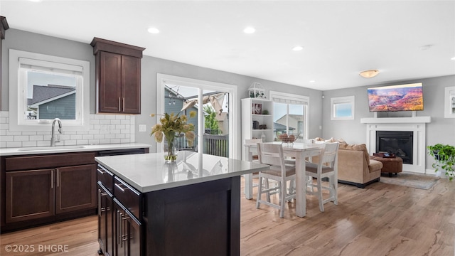 1208 NE 21st St, Grimes, IA 50111 - kitchen featuring a glass covered fireplace, light countertops, healthy amount of natural light, light wood-style flooring, and recessed lighting