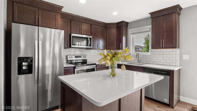 1208 NE 21st St, Grimes, IA 50111 - kitchen with appliances with stainless steel finishes, light countertops, decorative backsplash, dark brown cabinetry, and recessed lighting