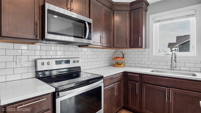 1208 NE 21st St, Grimes, IA 50111 - kitchen with appliances with stainless steel finishes, light countertops, decorative backsplash, and dark brown cabinetry