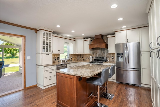 4785 Windsor Cir, Pleasant Hill, IA 50327 - kitchen featuring appliances with stainless steel finishes, premium range hood, dark wood finished floors, glass insert cabinets, and ornamental molding